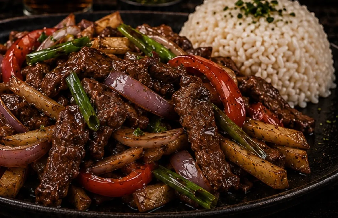 Lomo saltado con cebolla, tomate, papas fritas y arroz